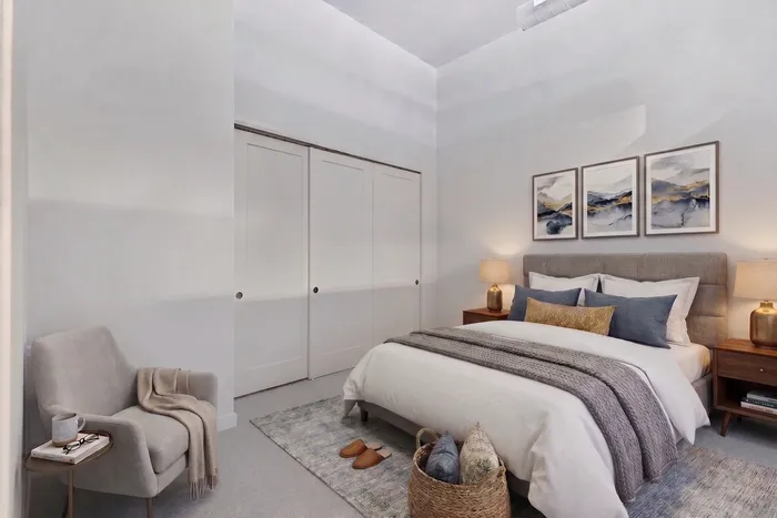 Cozy bedroom featuring a plush double bed, modern nightstands with warm lighting, elegant wall art, and a comfy reading chair.
