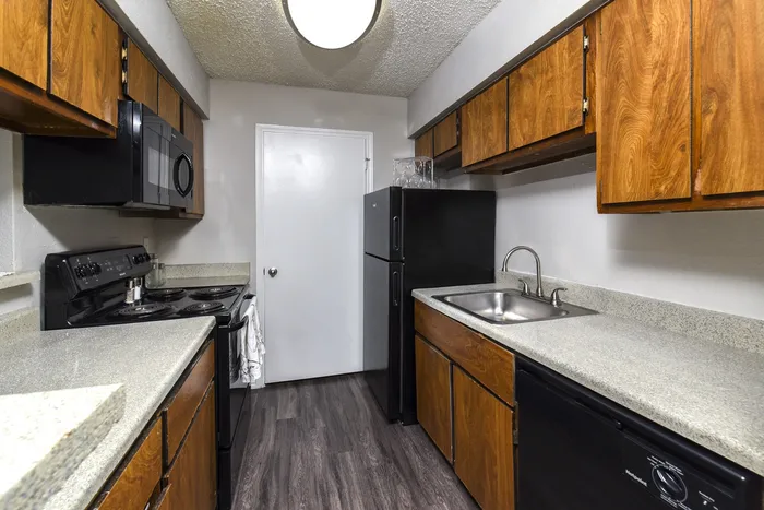 Galley Kitchen | Wood Cabinets | Black Appliances