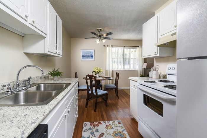 Galley Kitchen | White cabinets | White appliances | plank flooring