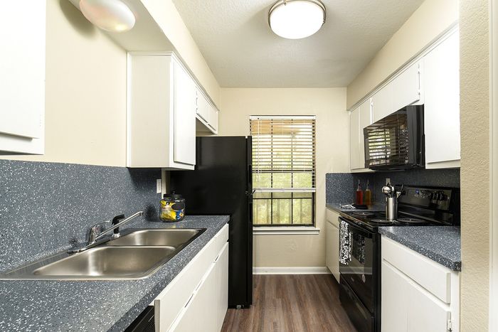 2/2 Classic Kitchen | black appliances | plank flooring | gray speckled countertops