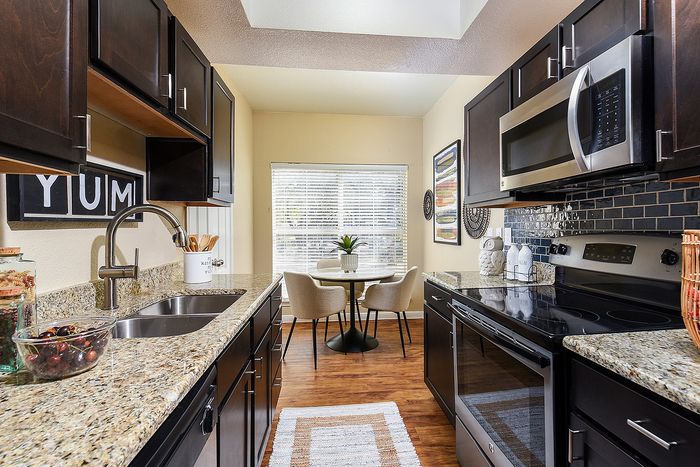 Galley kitchen| Granite countertops| Espresso color cabinets | plank flooring | Stainless steel appliances