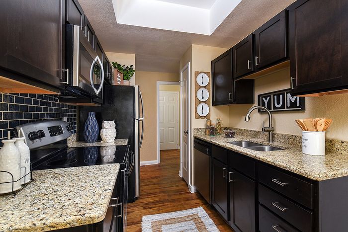 Galley Kitchen | granite countertops | Espresso color cabinets | plank flooring | stainless steel appliances
