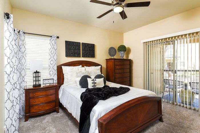 Bedroom | ceiling fan | sliding glass doors that go out to a small patio | 2 windows