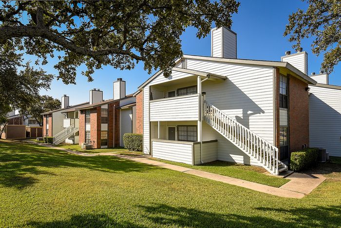 Exterior of building | White siding with brick accents | Chimneys from fireplaces