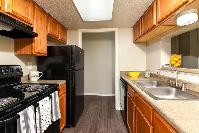 Classic One Bedroom | kitchen with oak cabinets and black appliances