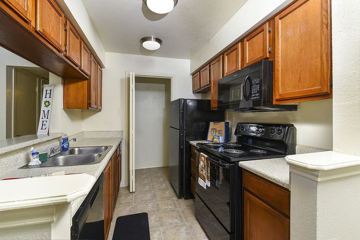 Galley Kitchen | Black Appliances | Oak Cabinets