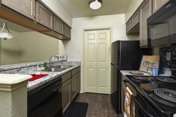 Kitchen | Granite countertops | Black appliances | Plank Flooring