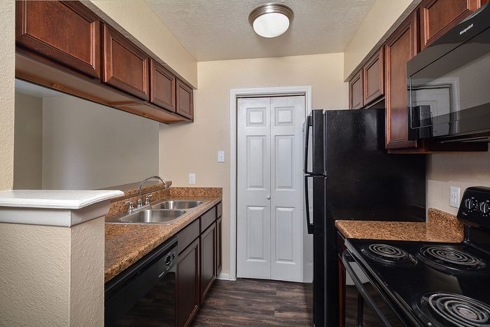 Townhome | Kitchen with plank flooring and black appliances