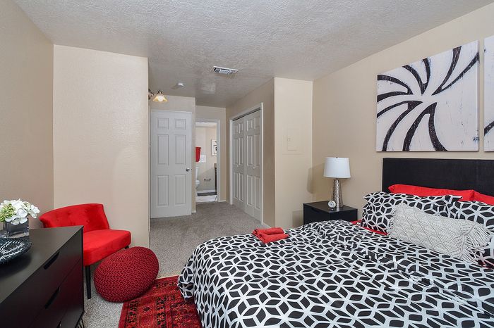 B Floor Plan | Black white and red primary bedroom with closet area and bathroom