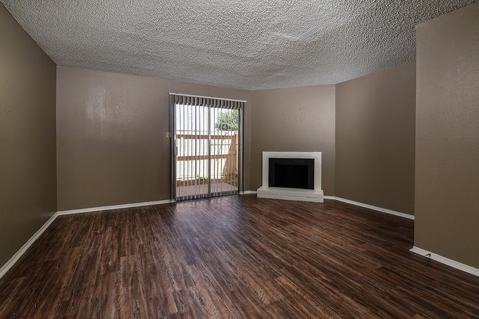 Living area | Fireplace | Plank flooring | sliding glass door that leads to a patio