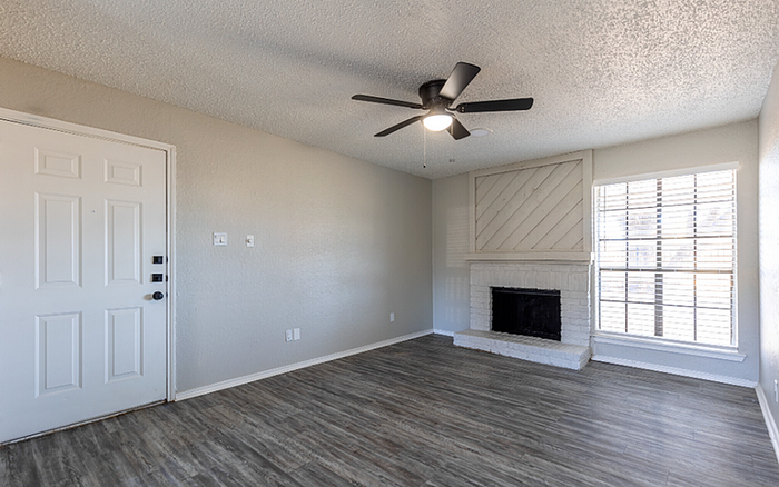 B1 floor plan designer welcoming living room with modern ceiling fan, stylish fireplace, and large window.