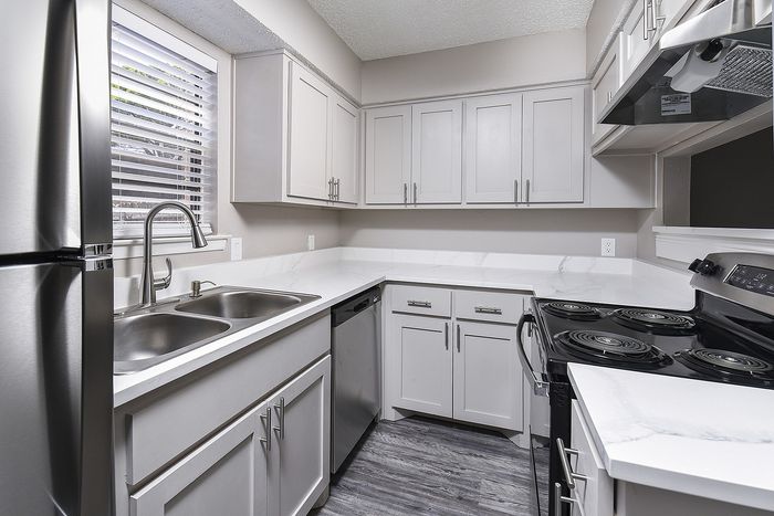 Kitchen with stainless steel appliances, gray cabinetry.