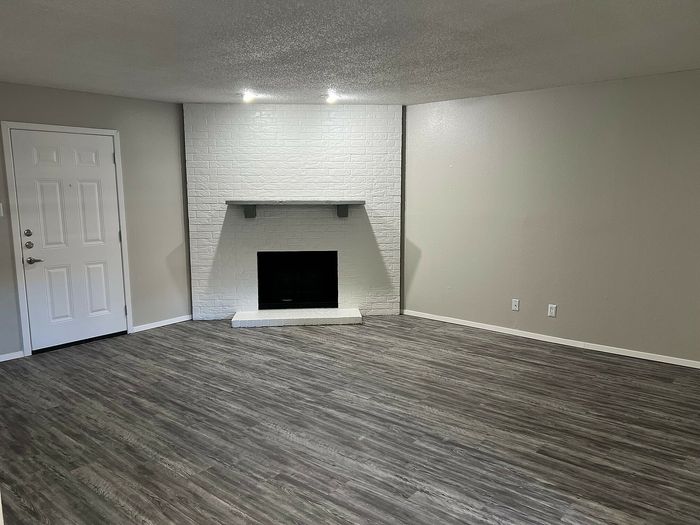 Inviting living room with a stylish fireplace and vinyl plank flooring.
