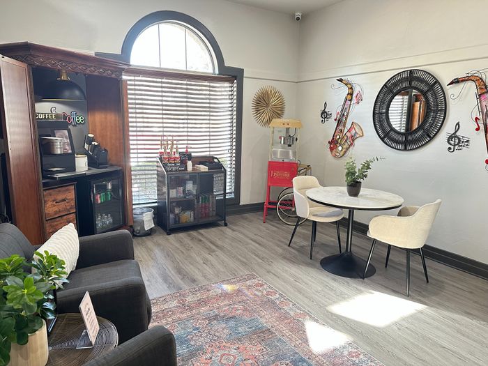 Stylish apartment lounge featuring a coffee station, cozy seating, and modern decor with musical elements.