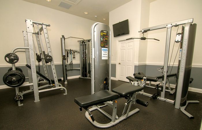 Modern apartment gym featuring state-of-the-art fitness equipment and sleek design for a comprehensive workout experience.
