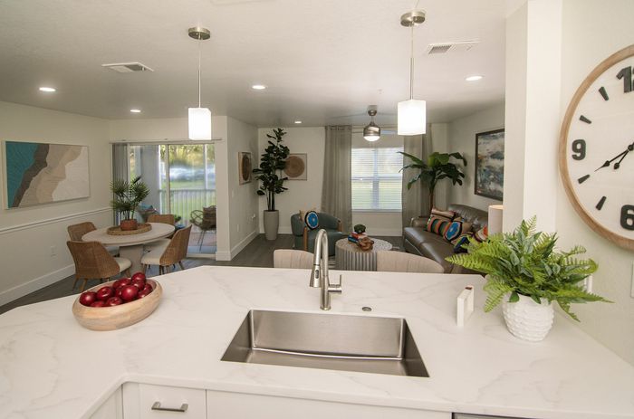 Modern open-concept apartment with sleek kitchen island, cozy living area with natural light, elegant dining space, and stylish decor.