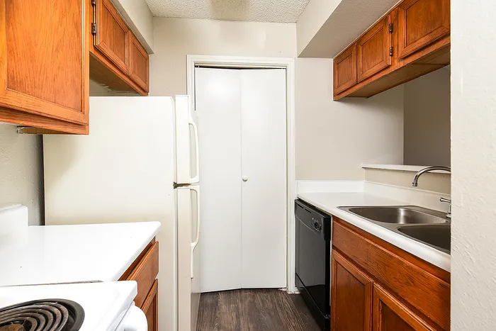 Charming kitchen featuring warm wooden cabinets, sleek white countertops, and a full range of modern appliances.