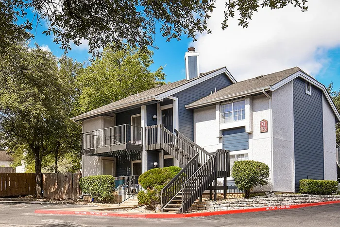 Charming apartment building surrounded by lush greenery and featuring modern exterior design, perfect for serene living.
