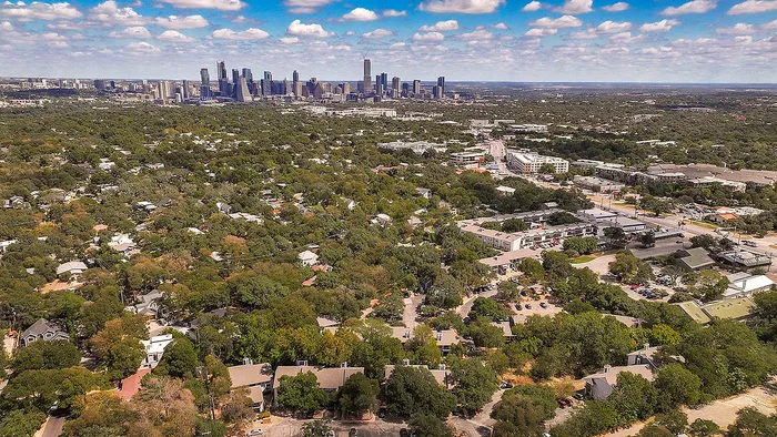 Scenic aerial view showcasing a vibrant city skyline surrounded by expansive green neighborhoods, perfect for tranquil living close to urban amenities.