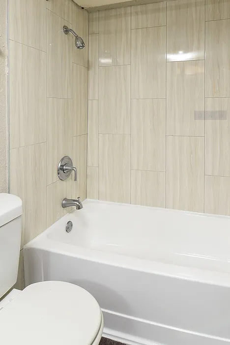 Modern bathroom featuring elegant tiled walls and a pristine bathtub, perfect for relaxation.