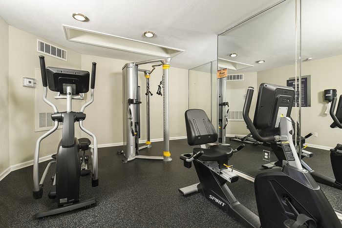Fitness center featuring state-of-the-art exercise equipment, mirrored walls, and sleek flooring for an optimal workout experience.