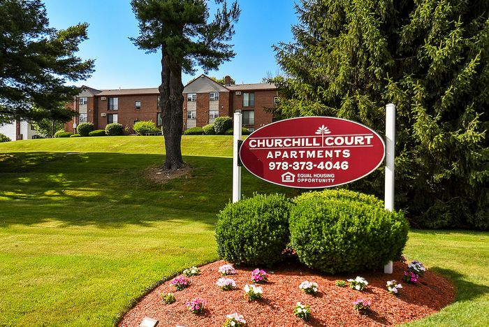 Charming Churchill Court Apartments nestled in lush greenery, offering a serene and welcoming atmosphere.
