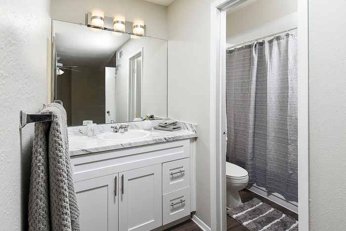 Bright and elegant bathroom featuring a sleek marble countertop with a stylish vanity and a modern shower area.