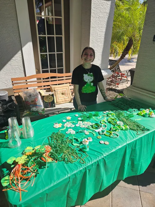 Cheerful outdoor St. Patrick's Day setup with a vibrant green table filled with festive decorations, including shamrock accessories, colorful beads, and cheerful tokens.