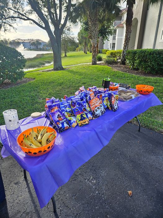 Charming outdoor setup with Halloween-themed snacks and d&eacute;cor set against a scenic lakeside view.