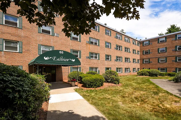 Charming brick apartment complex with lush landscaping and inviting entrance canopy at Eastview.