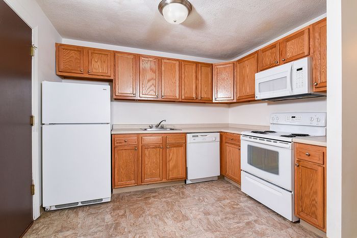 Inviting kitchen with wooden cabinetry, modern appliances, and ample countertop space.