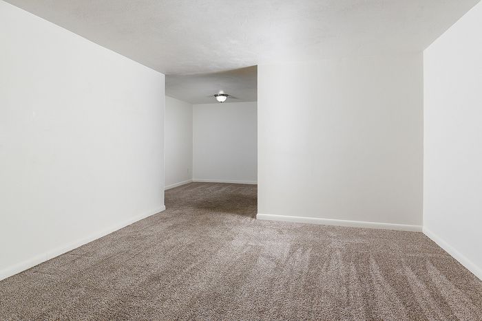 Bright and spacious room with plush carpeting and neutral walls, ideal for personalization.