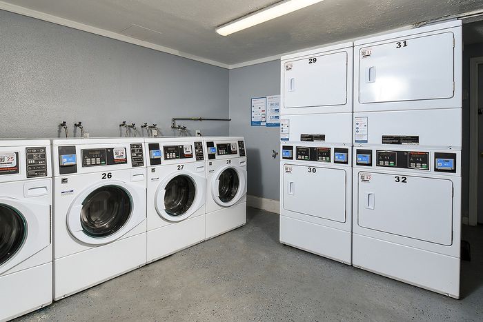 Modern laundry room with multiple high-efficiency washers and dryers, perfect for convenient apartment living.