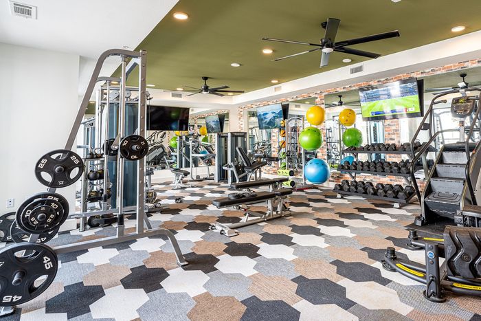 State-of-the-art fitness center featuring modern gym equipment, vibrant exercise balls, and mirrored walls for an inspiring workout experience.