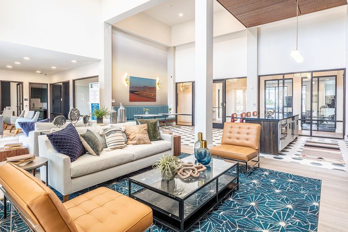 Chic and modern open-concept living space featuring stylish furniture, plush cushions, and elegant decor, perfect for entertaining in comfort and style.