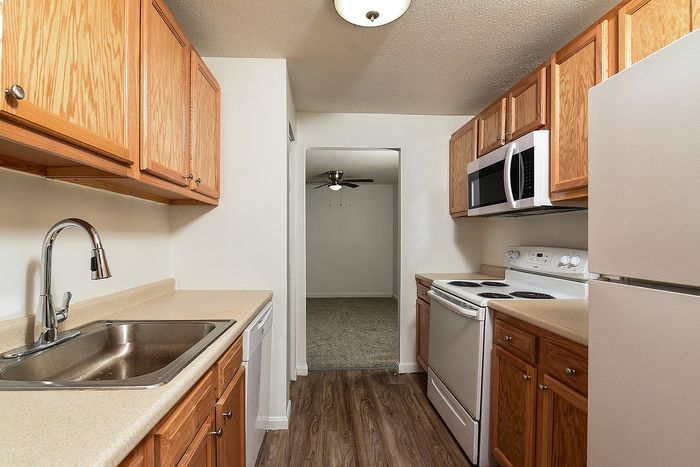 Charming kitchen with wood cabinetry, modern appliances, and sleek countertops, leading to a cozy dining area.