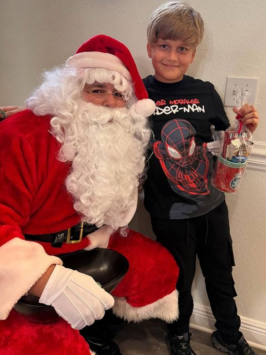 Santa with a young boy in a spider man tshirt