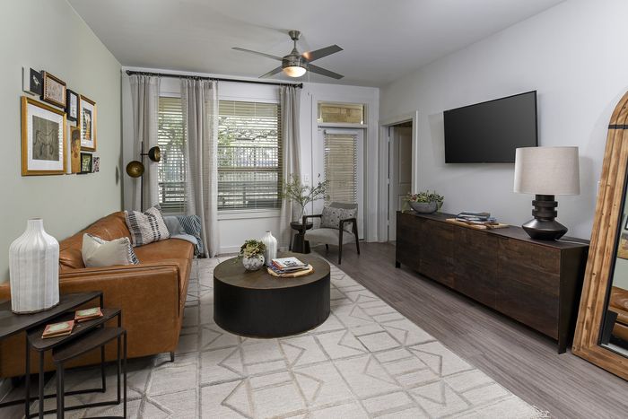 Chic living room with a cozy leather sofa, large wall-mounted TV, and modern decor, perfect for relaxing and entertaining.