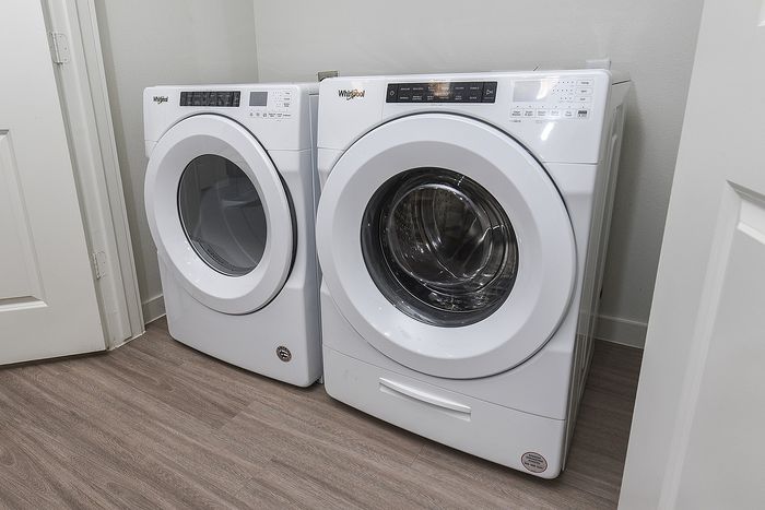Sleek and modern laundry room featuring high-efficiency washer and dryer on a stylish wood floor.