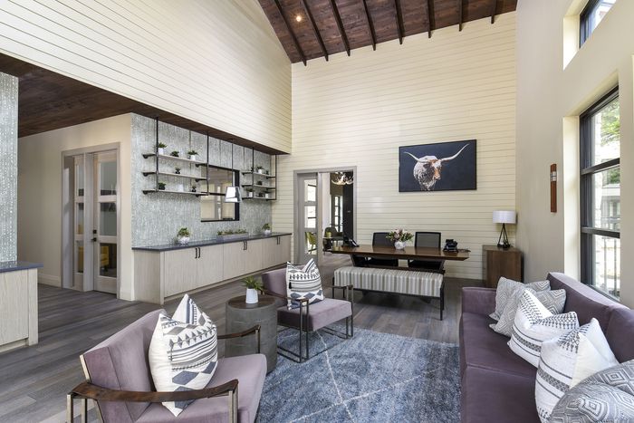 Chic and inviting lounge with high ceilings, modern decor, and cozy seating, perfect for relaxation and conversation.