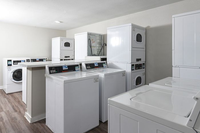 Modern laundry room with multiple washing machines and dryers, featuring sleek design and efficient layout.