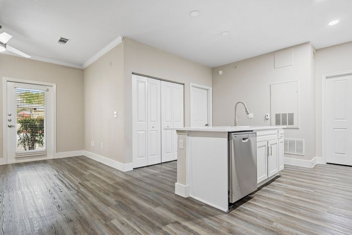 Bright and airy modern kitchen with sleek countertops, stainless steel appliances, and elegant flooring, highlighted by natural light from patio doors.