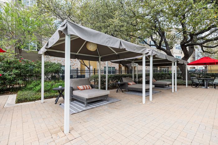 Inviting outdoor space with stylish cabanas and cozy lounge chairs, surrounded by lush greenery and a vibrant atmosphere.