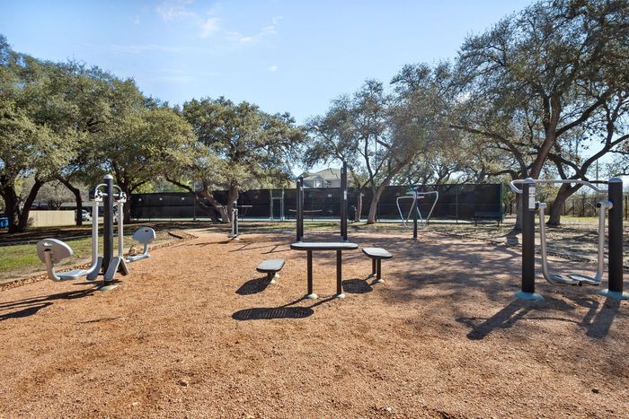 Inviting outdoor fitness park with modern exercise equipment nestled among lush trees, offering a serene workout environment.
