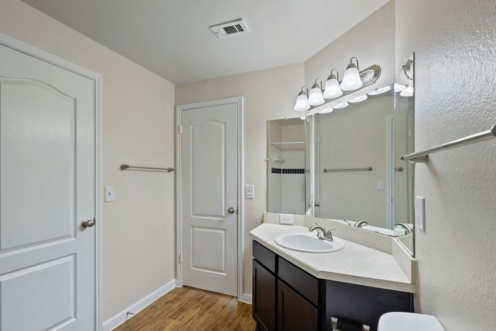 Bright and elegant bathroom with sleek vanity, large mirror, and modern lighting.