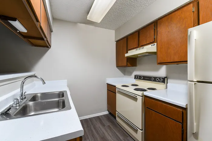 Charming kitchen with sleek countertops, twin sinks, and classic wooden cabinetry for a timeless touch.