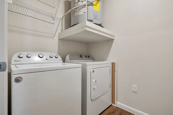 Modern laundry room featuring a stylish washer and dryer set against neutral walls and hardwood flooring.