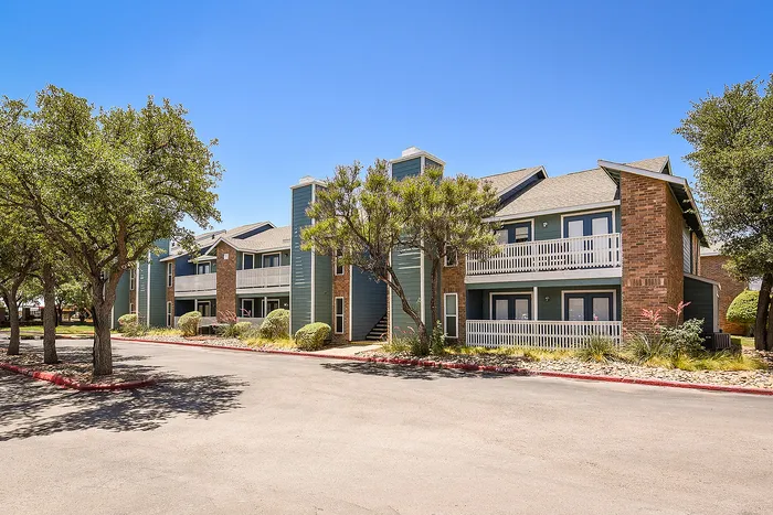 Charming apartment complex with modern architecture, surrounded by lush greenery and serene pathways.
