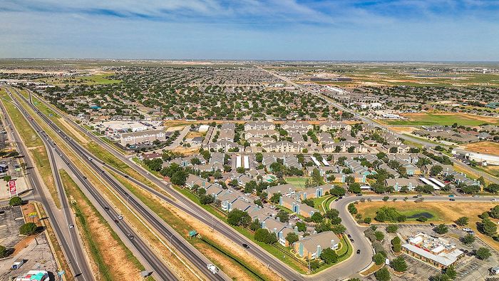 Expansive aerial view of a vibrant residential neighborhood with well-planned roads, lush greenery, and accessible amenities.