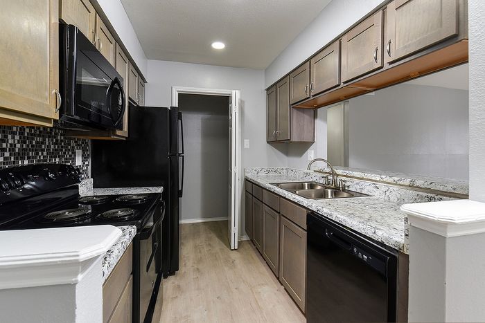Modern galley kitchen featuring sleek granite countertops, stylish cabinetry, and top-of-the-line appliances.